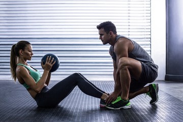 Muscular couple doing abdominal ball exercise - Powered by Adobe