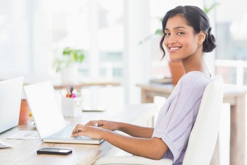  Cheerful casual businesswoman using laptop