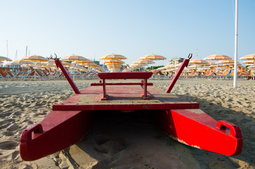 Travel beach Romagna - beach and sea in Rimini with red rescue boat closeup