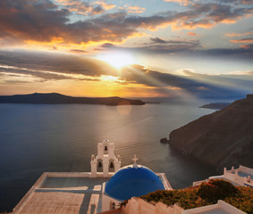 Santorini island with church against colorful sunset in Greece
