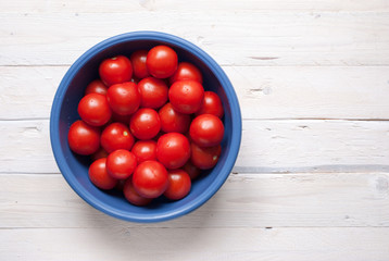 view from above of lot of tomatoes in a blue container