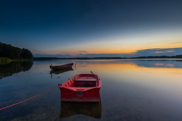 Beautiful lake sunset with fisherman boat