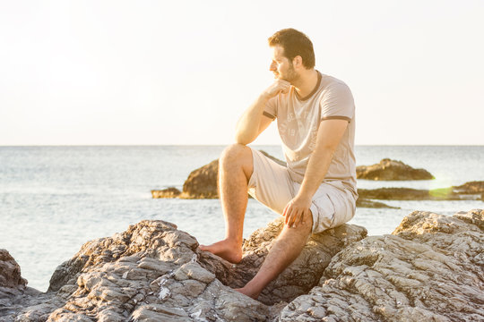 Man at the beach watching the sunrise/ sunset
