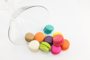 Colorful macaron and wine glass on white background.