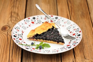 Piece of homemade vegan galette with wild blueberry on painted p