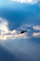 silhouette of a helicopter in the rays