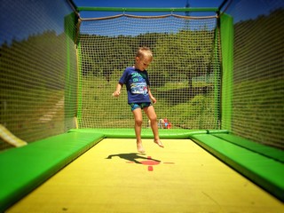 bimbo che salta su tappeto elastico