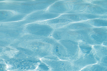 Blue pool water with sun reflections
