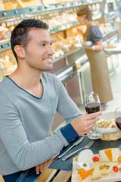 Man having meal, holding glass red wine