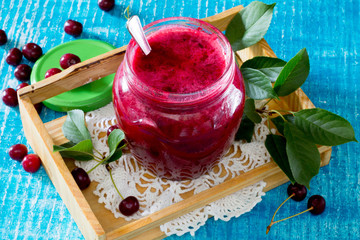 Cherry jam on a wooden background