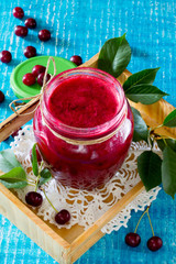 Cherry jam on a wooden background