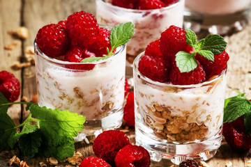 Homemade granola with yogurt, raspberry and mint  in glass bowls