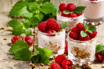 Homemade granola with yogurt, raspberry and mint  in glass bowls