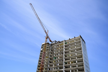 Fototapeta na wymiar demolition of a skyscraper with a high crane