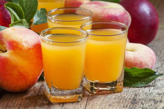 Fresh peach juice with fruits on a  wooden background, selective