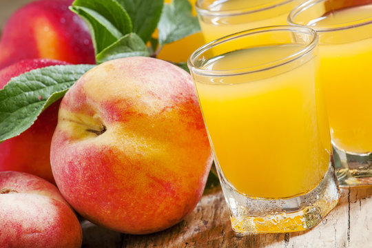 Fresh peach juice with fruits on a  wooden background, selective