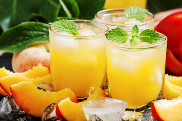 Cold fresh peach nectar with pulp, ice and mint, selective focus