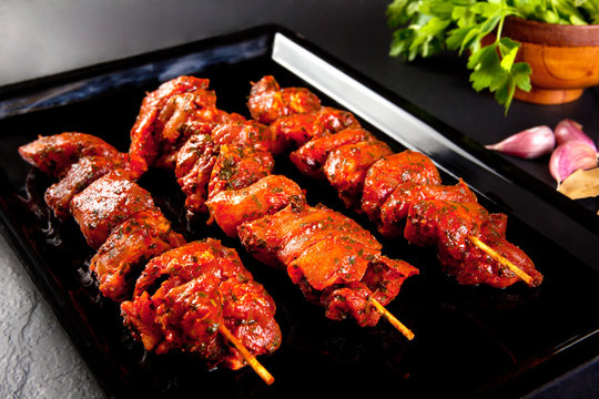 
Pinchos de cerdo a la parrilla y barbacoa. Naturaleza muerta sobre fondo negro