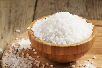 Fototapeta na wymiar Large white sea salt in a wooden bowl, selective focus