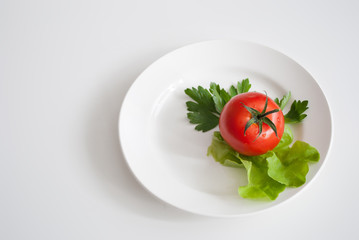 three tomatoes with salad on a plate