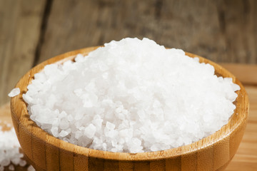 Large white sea salt in a wooden bowl, selective focus
