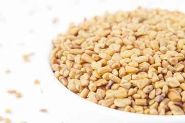 Fenugreek seeds in white bowl 