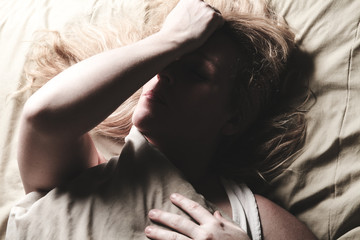 A woman feel sick lying down on bed © Louis-Paul Photo