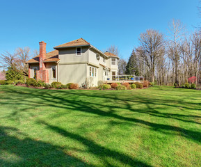 Fototapeta na wymiar Large back yard with greenery, and furnished back porch.
