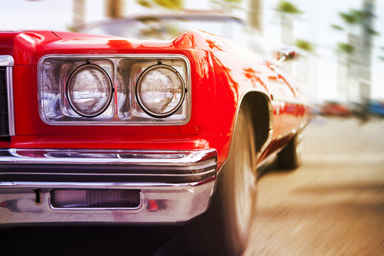 Red Classic Car Driving Fast, With Motion Blur Background. Close Up View
