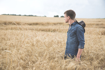 Naklejka na ściany i meble Young man standing in a field