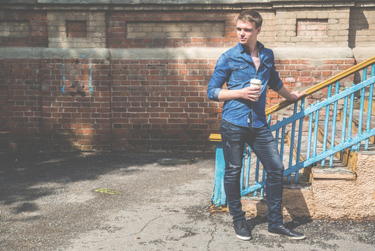 Handsome Guy With A Mug Of Coffee In The Old Building