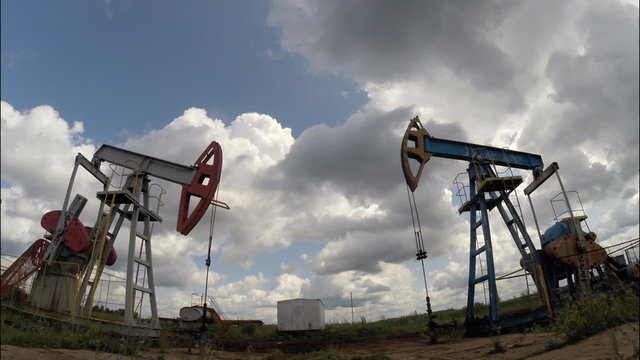 Oil pumps. Oil industry equipment. Storm clouds. moving camera 