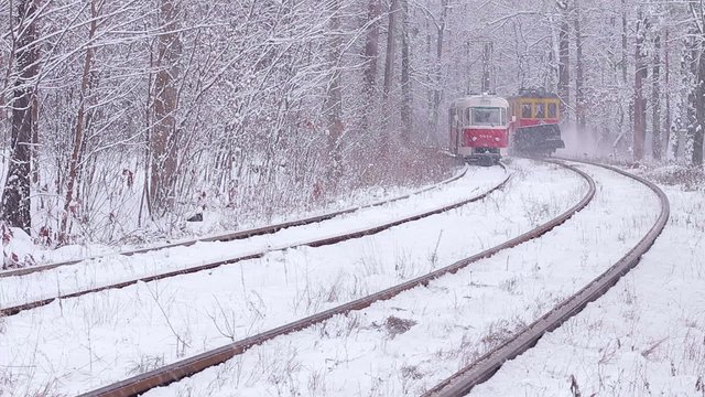 Tram go in the winter forest. Railway in winter wood.