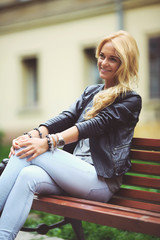 beautiful young blond woman on a bench in the summer