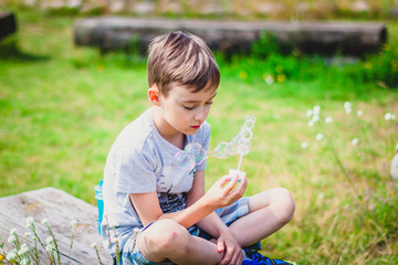 Boy sitting on a bench with soap bubbles