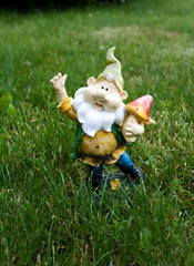 Clay garden gnome on a green lawn