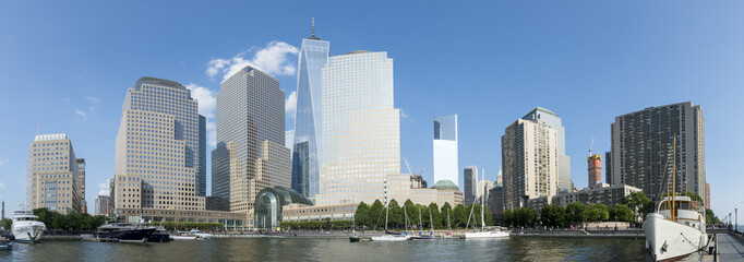 Naklejka premium Downtown Manhattan New York City skyline featuring modern office towers under bright blue sky panorama
