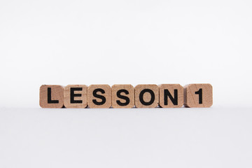 lesson one - text on wooden cubes, isolated on white background