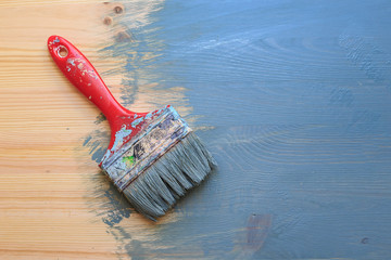 Old used paint brush on partial paint wood background. Diagonal