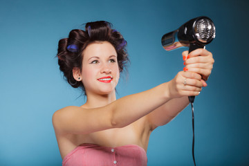 girl with curlers in hair holds hairdreyer