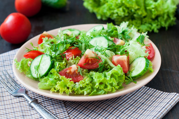 Tomato and cucumber salad with lettuce leafes
