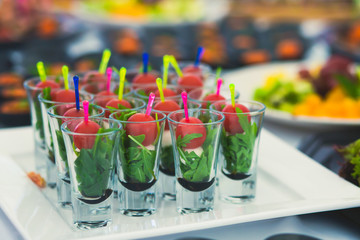 Beautifully decorated catering banquet table with different food snacks and appetizers with sandwich, caviar, fresh fruits on corporate party event or wedding celebration