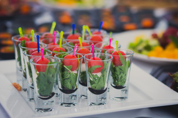 Beautifully decorated catering banquet table with different food snacks and appetizers with sandwich, caviar, fresh fruits on corporate party event or wedding celebration