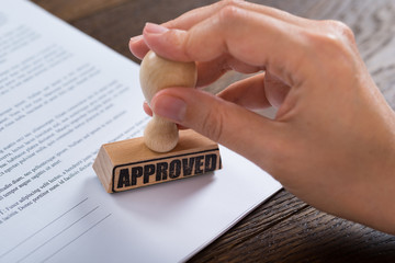 Person Hands Using Stamper On Document