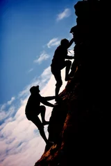 Fotobehang Siluet two men climb up the mountain © vladmilkov