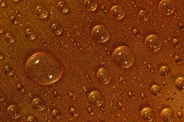 Water drops on the brown surface. Selective focus.