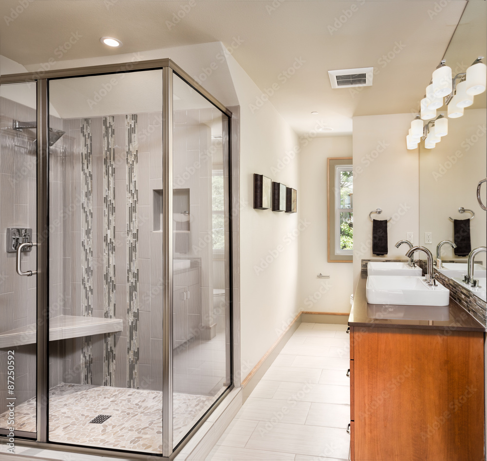 Wall mural Beautiful bathroom in new home with two sinks, large shower and mirror, and tiled floor