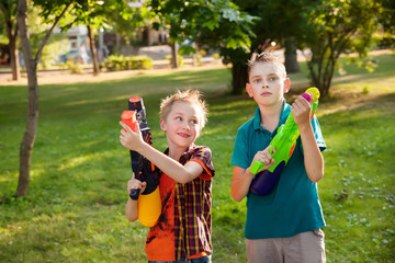 Fototapeta premium happy boys playing with water guns