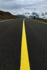 High altitude road into the mountains in foggy day
