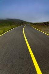 High altitude road into the mountains in foggy day